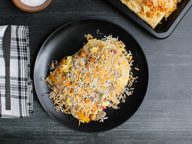 Chicken sausage breakfast flatbread with scrambled eggs, peppers, onions, and melted cheese