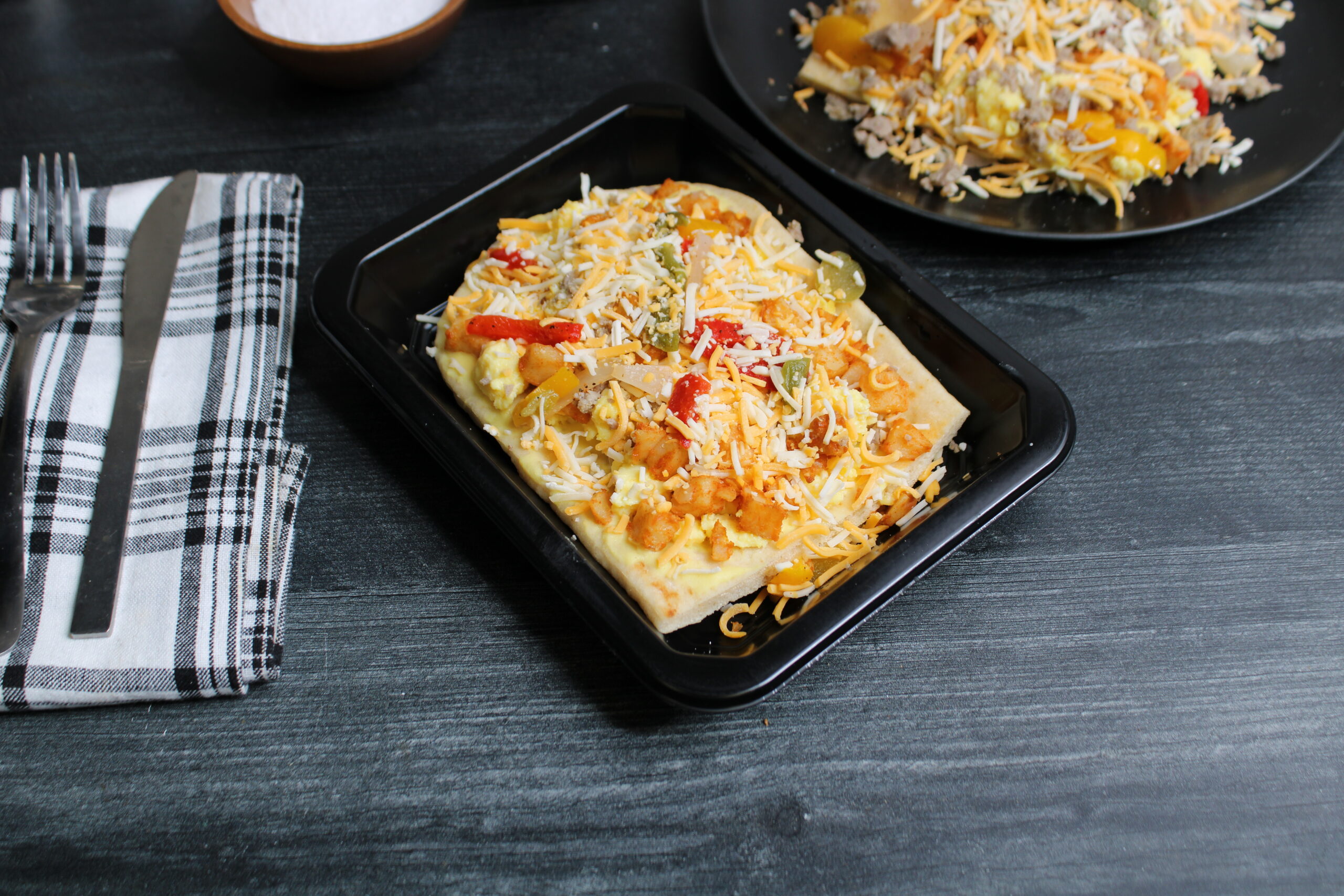 Chicken sausage breakfast flatbread with scrambled eggs, peppers, onions, and melted cheese